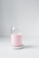 Pink milkshake in a can shaped glass, strawberry raspberry milkshake in a glass shaped like a can, Aesthetic cafe pink milkshake in a can glass