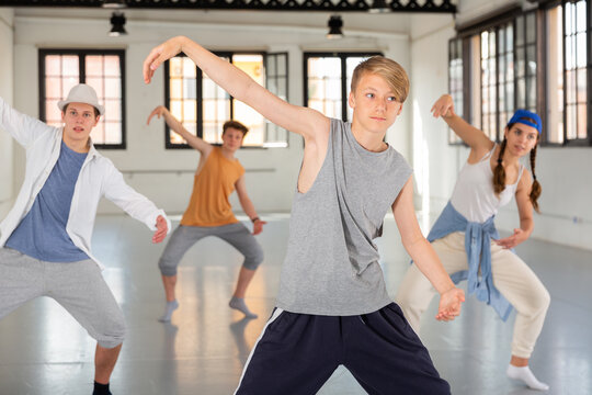 Portrait of teenage boy performing hip hop elements at group dance training in studio © JackF