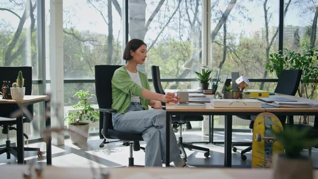 Manager making tea sip in office work break. Girl holding cup coffee beverage