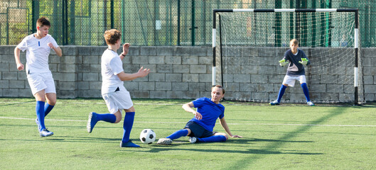 Youthful football player tackling ball from opponent player