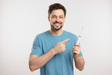 Happy man holding electric toothbrush on white background - Powered by Adobe