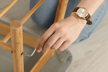 Woman with hex key assembling furniture on floor, closeup