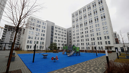 Modern urban architecture, white apartment building in the city and children playground. Stock footage. New high rise flat complex in residential neighborhood.