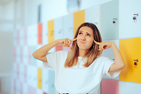 Stressed Teacher Hearing a Lot of Noise in a School Hall. Frustrated school headmaster hearing all the noise you know college hall way
