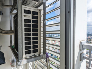 A split type inverter air conditioning condenser mounted outside a studio condo apartment unit...
