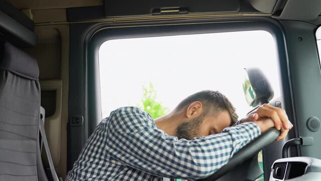 Tired truck driver in a cabin of his truck. Lack of sleep