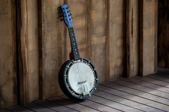 Banjo Mandolin on a veranda. Vertical wooden clading