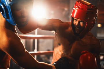 Two athletic and muscular body boxers with safety helmet or boxing head guard face off in fierce boxing match. Boxing fighter competitor fighting in the boxing ring. Impetus - obrazy, fototapety, plakaty