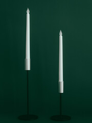 Two beautiful electronic candles on a green background.