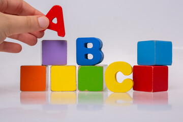 Hand playing with Colorful alphabet letters and building bloks - obrazy, fototapety, plakaty