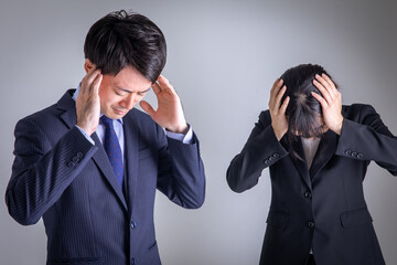頭を抱える男女　Business