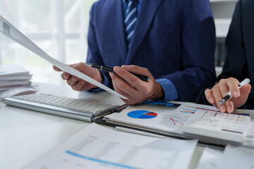 team work process Business team use calculator to calculate figures, business statistics, profit, cost analysis, growth rate graph document. data charts on the desk