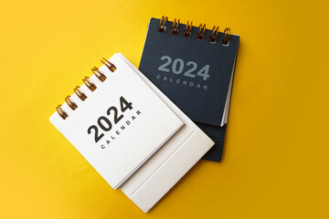 January 2024 - Closeup of a small desktop calendar with yellow background, time and business concept