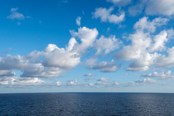 Naklejka na ściany i meble Blue-gray cloudy sky over the Caribbean Sea horizon