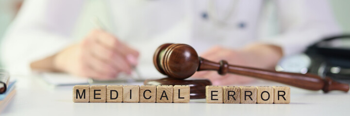 Gavel lies on wooden blocks put in words Medical Error