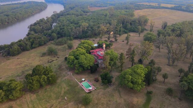 Drone shot flying down while panning up with the estancia Santa C&aacute;ndida in the center of the frame on a hazy day.