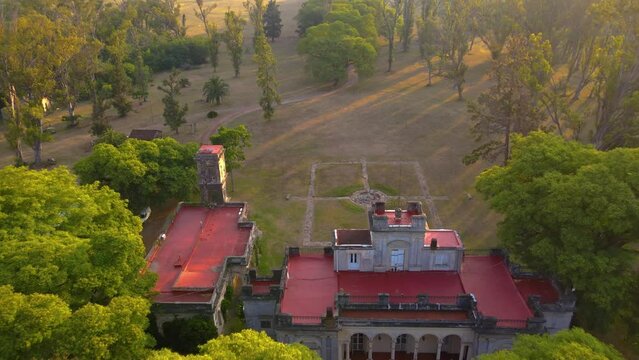Drone shot flying backwards, panning up to reveal the estancia Santa C&aacute;ndida during golden hour.