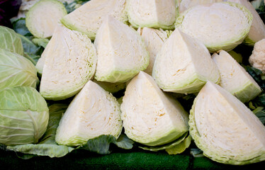 Fresh organic heads of cabbages cut in pieces on the farmers market.