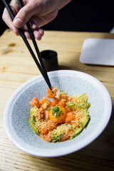 Japanese gourmet salmon tartar with quail egg on top and chopsticks. 