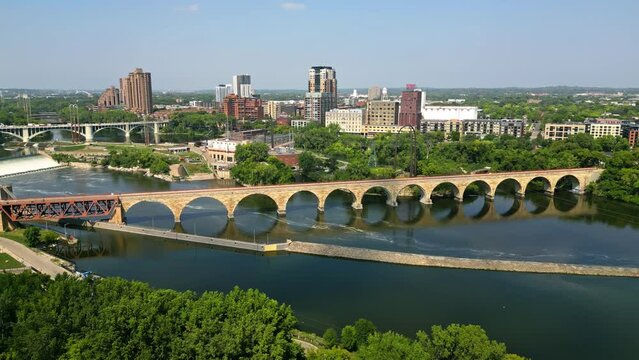Stone Arch Bridge Over Mississippi River Near Saint Anthony Falls In Downtown Minneapolis, Minnesota, USA. Aerial Shot