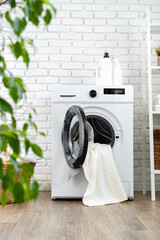 Detergent bottle on washing machine in a laundry room - obrazy, fototapety, plakaty