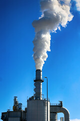 Komin rafinerii naftowej wypuszcza gesty dym z komina.