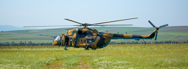 A soldier in camouflage goes to a military helicopter. Military helicopter with soldiers. Armed...