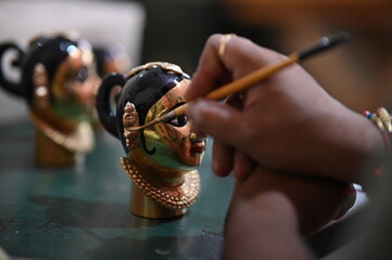 coloring of Goddess face. Hindu Goddess making statue. Face coloring proccess. Golden colors. Brush...