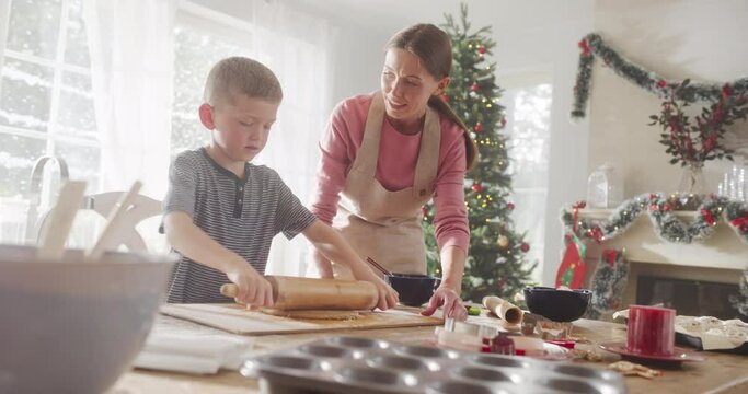 Slow Motion Portrait of Woman and her Son Baking Together During Christmas. Mother Teaching her Little Boy How to Make Gingerbread Cookies. Child Helping his Mother with Cooking for Holidays
