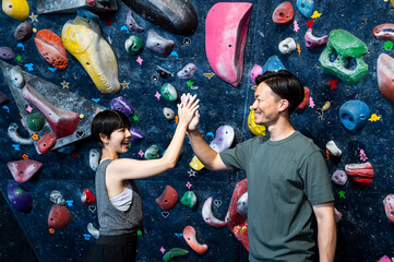 Asian men and women doing high five in a bouldering gym. Healthy living. Physical and mental...
