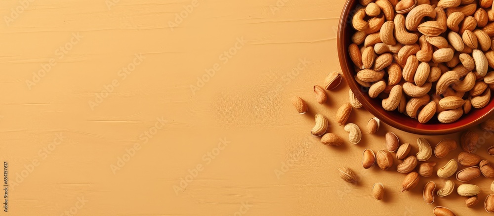 Poster peanuts in a brown bowl on a isolated pastel background copy space used for making oil and peanut bu