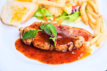 Grilled chicken steak, fries and vegetables on white background