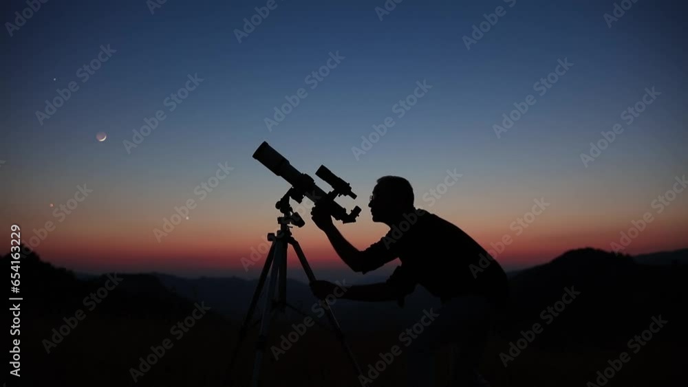 Wall mural astronomer looking at the stars, planets, moon and celestial objects with a telescope.