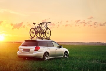 Passenger car with two bicycles mounted to the roof. Roof-mounted bikes. Sports equipment...