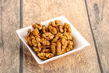 Cracked unshelled walnut in the bowl