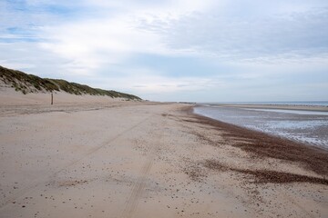 very wide empty sandy beach at low tide in the morning