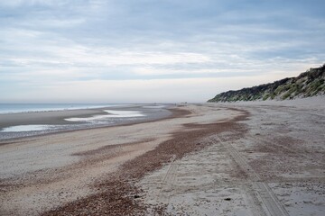 very wide empty sandy beach at low tide in the morning