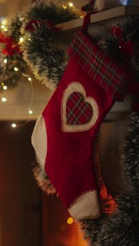 Vertical Screen: Close Up on Decorated Fireplace with Stockings Next to a Christmas Tree. Green and Red Garlands, Ribbons and Lights. Empty Shot on a Peaceful Snowy Christmas Eve