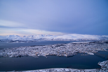 Fototapeta na wymiar Evening view from the top of the mountain in Tromso, Norway. Polar circle, in winter. Fjord, polar sea. Dark evening. Breath-taking view. Town, city from the top, drone view, on island. Polar night