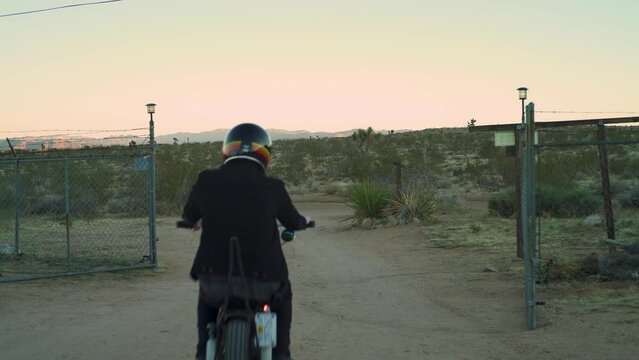 Come along on the open road in this cinematic clip captures as a lone adventurer arrives at an enchanting old farm in the heart of the desert, riding a vintage chopper motorcycle.