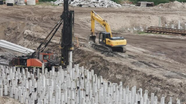 Driving piles with a pile driving machine at a construction site. Construction of the foundation.