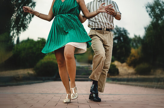 Swing Dance Steps in Motion - Close-up of dancers' feet and attire in swing dance outdoors. Distinctive vintage style details
