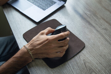 Male hand using computer mouse at home.