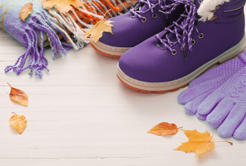 purple winter shoes and gloves on white wooden background