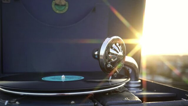 Listening to Vinyl Records on a Retro Gramophone at Sunset.