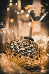 Close-up of Christmas baubles on a table decorated for Christmas, warm gold colors, vertical