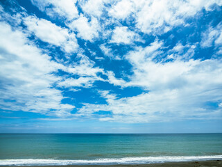 Fototapeta na wymiar The Seashore and the Blue Sky with White Clouds
