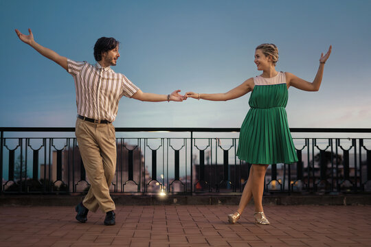 Swing Dancers on Terrace with Open Sky: Couple dancing in profile on a terrace, vast backdrop ideal for copy space.