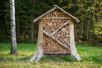 Wooden insect hotel, shelter for wild insects in forest reserve. House for wasps made of logs