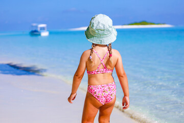 child in bikini on beach in the maldives, model shooting 
